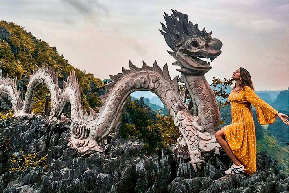 Strike a pose beside the legendary dragon statue – an iconic photo spot at Mua Caves